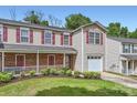 Traditional townhome featuring red shutters, a cozy porch, and well-maintained landscaping, perfect for comfortable living at 6335 Ziegler Ln, Charlotte, NC 28269