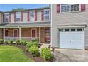 Attractive townhome featuring a brick front porch and attached garage, complemented by a neat lawn and shrubbery at 6335 Ziegler Ln, Charlotte, NC 28269