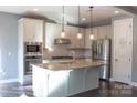 Modern kitchen featuring stainless steel appliances, marble backsplash, and a large kitchen island at 745 Garrett Green Way, Fort Mill, SC 29715