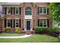 Charming brick home entrance showcases a classic black door and well-maintained landscaping at 8227 Lansford Rd, Charlotte, NC 28277