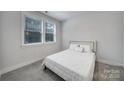 Serene bedroom with natural light, plush carpet, and a comfortable queen-size bed with white linens at 8723 Nolley Ct, Charlotte, NC 28270