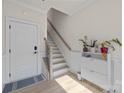 Inviting entryway features a modern staircase, and stylish decor with sleek white accent furniture at 8723 Nolley Ct, Charlotte, NC 28270