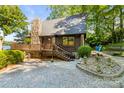 Inviting home with stone chimney, wooden deck, and meticulously landscaped yard at 9289 Azalea Rd, Sherrills Ford, NC 28673
