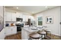 Bright kitchen featuring stainless steel appliances, granite countertops, a breakfast bar, and white cabinetry at 118 Parker Claire Ln, Kings Mountain, NC 28086
