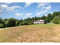 A long shot of a home nestled in a spacious, wooded lot with a long driveway at 1221 Woodpecker Dr, Clover, SC 29710