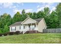 A well-manicured lawn complements this inviting home with a covered front porch at 1221 Woodpecker Dr, Clover, SC 29710
