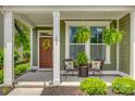 Inviting covered front porch with seating area, ferns, and decorative wreath at the home's entrance at 155 Boxelder Rd, Clover, SC 29710