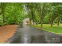 Long paved driveway leading to a charming home surrounded by mature trees at 1669 Mary Ellen Dr, Fort Mill, SC 29708