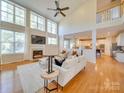 Bright living room with fireplace, hardwood floors, and soaring ceilings with large windows at 1708 Aringill Ln, Matthews, NC 28104