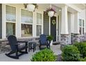 Inviting front porch features rocking chairs and hanging plants with a stylish stone base at 2062 Nellies Way, Fort Mill, SC 29715