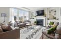 Bright living room features a cozy fireplace, large windows, and stylish decor at 2062 Nellies Way, Fort Mill, SC 29715