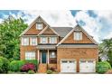 Charming brick two-story home with a well-manicured lawn and a two-car garage at 208 Mcduffie Ln, Fort Mill, SC 29715