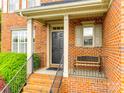Inviting front porch with brick steps, metal railing and a bench creating a cozy entrance at 208 Mcduffie Ln, Fort Mill, SC 29715