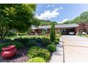 Beautiful brick home featuring mature landscaping, colorful flowers, and a covered carport at 3008 Imperial Dr, Gastonia, NC 28054