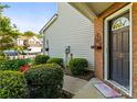 Charming front door entrance with lush bushes and an ornate, decorative door hanger at 3129 Summerfield Ridge Ln, Matthews, NC 28105