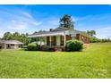 Inviting brick home featuring a covered porch and well-maintained landscaping, blending classic design with welcoming curb appeal at 335&315 Graham Rd, Mt Ulla, NC 28125