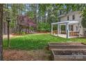 Large backyard features a pergola-covered patio, raised garden beds, and a wooded backdrop at 3617 Ruth St, Indian Trail, NC 28079