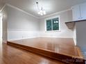 An open-concept dining room featuring chair rail molding, hardwood floors, and a large window at 404 Kings Dr # 7, Cherryville, NC 28021