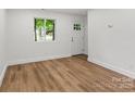 Living room with hardwood floors and bright light from the front door window at 5444 Datha Ave, Charlotte, NC 28269