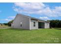 The back of the house has gray siding, a covered patio, and a spacious lawn at 5607 Skinny Dr, Charlotte, NC 28215