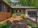 Inviting front entrance with brick walkway, gray garage door, and stylish accents at 6001 Charing Pl, Charlotte, NC 28211