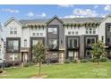 Modern townhome features a stylish gray and white facade, complimented by a well-maintained lawn and black fencing at 614 West End Dr, Charlotte, NC 28208
