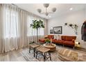 Cozy living room features a plush rust-colored sofa, woven stools, and plenty of natural light from sheer curtains at 614 West End Dr, Charlotte, NC 28208