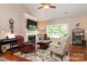 Comfortable living room with a fireplace, ceiling fan, large window, and stylish decor at 6398 Winding Creek Ln, Denver, NC 28037