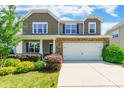 Two story home with neutral siding, brick accents, landscaping and two car garage at 7711 Kelburn Ln, Charlotte, NC 28273