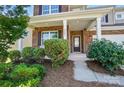 Inviting front porch with brick columns and manicured landscaping creates a warm welcome to this lovely home at 9301 Swimming Dr, Harrisburg, NC 28075