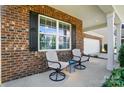 Cozy covered front porch features comfortable seating, creating a relaxing outdoor space adjacent to the home's entry at 9301 Swimming Dr, Harrisburg, NC 28075