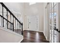 Bright foyer with hardwood floors, staircase with black iron spindles, and elegant front door at 9647 Laurie Nw Ave, Concord, NC 28027