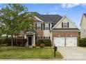 Two-story home with brick and siding, mature tree, well-manicured lawn, and a two-car garage at 9647 Laurie Nw Ave, Concord, NC 28027