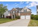 Two-story home with brick and siding, long driveway, well-manicured lawn, and a two-car garage at 9647 Laurie Nw Ave, Concord, NC 28027