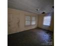 Aged living room featuring hardwood floors, windows with blinds, and a damaged ceiling at 1015 Frederick St, Shelby, NC 28150