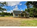 Inviting single-story house featuring green siding, covered entryway, and a spacious yard with trees at 1050 Beaten Path Rd, China Grove, NC 28023