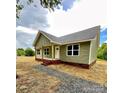 Attractive one-story home with green siding, brick foundation, and covered porch, complemented by gravel walkway at 1050 Beaten Path Rd, China Grove, NC 28023