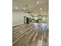 Spacious open-concept living area featuring modern wood floors, vaulted ceiling, and stainless steel kitchen appliances at 1050 Beaten Path Rd, China Grove, NC 28023