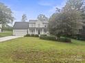 Traditional two-story home with covered porch and landscaped yard on a lush green lawn at 10749 Kingsview Dr, Davidson, NC 28036