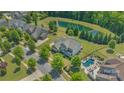 Aerial view of property showcasing pool, lush landscaping, and proximity to pond at 11333 Preservation Ln, Charlotte, NC 28278