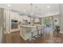 Modern white kitchen with granite countertops, stainless steel appliances, and island with seating at 11333 Preservation Ln, Charlotte, NC 28278