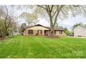 Brick home with a large front lawn and a mature shade tree at 125 Southwood Park, Mooresville, NC 28117