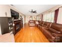 Spacious living room featuring hardwood floors, a fireplace and a large leather couch at 125 Southwood Park, Mooresville, NC 28117