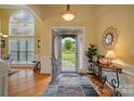 Inviting foyer with hardwood floors, decorative rug, and sunburst mirror at 129 Daniel Efird Dr, Mount Holly, NC 28120