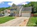 Charming two-story home featuring blue shutters, a well-manicured lawn, and a two car garage at 13430 Norseman Ln, Huntersville, NC 28078