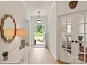 Bright entryway with wood floors, decorative mirror, and a view of the front door and green outdoor space at 1381 Regions Blvd, Fort Mill, SC 29707