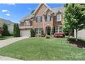 Charming two-story brick home with black shutters, a well-maintained lawn, and lush greenery at 15247 Prescott Hill Ave, Charlotte, NC 28277