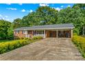 Inviting single-story brick home featuring a convenient carport and well-maintained front yard landscaping at 157 E Meadowview Dr, Statesville, NC 28625