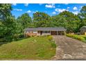 Attractive brick home with a spacious front yard, carport, and inviting curb appeal surrounded by mature trees at 157 E Meadowview Dr, Statesville, NC 28625