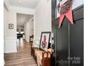Welcoming foyer with a bench, complemented by hardwood floors and a charming view into the living room at 174 Hanks Bluff Dr, Mooresville, NC 28117